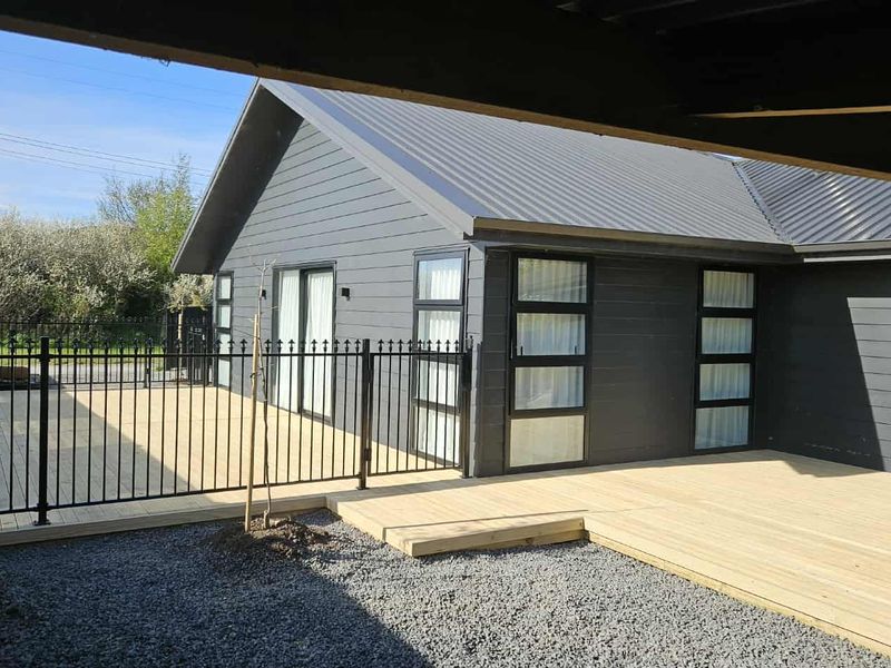 New timber deck built off a modern house with a black alloy fence enclosing it