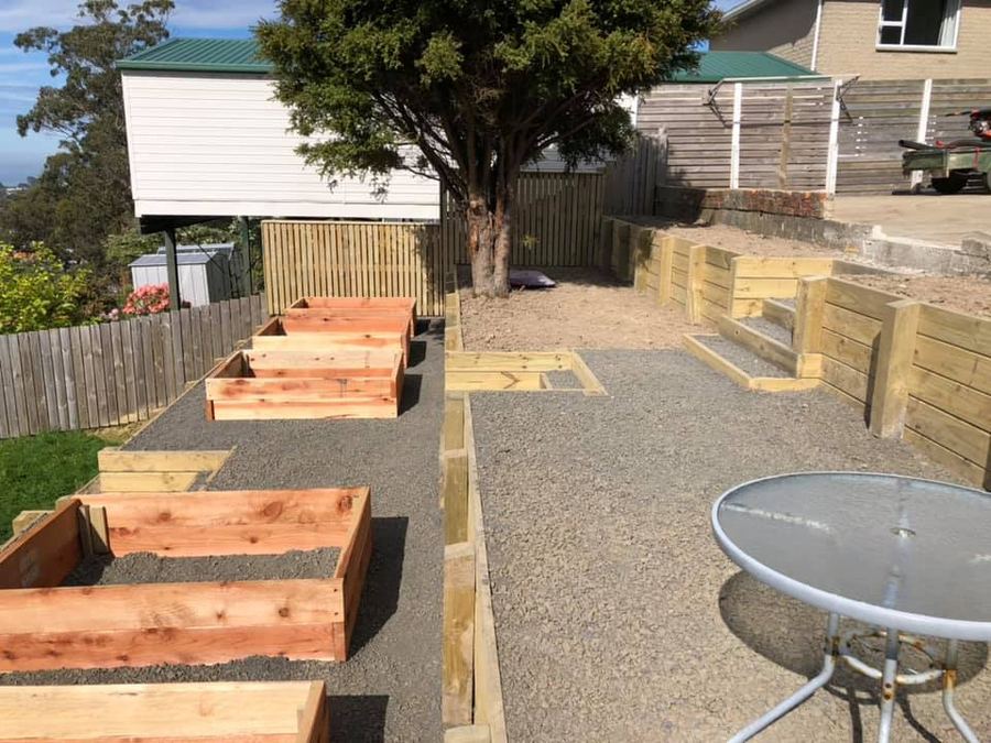 Terraced timber retaining wall with raised garden beds built into a sloping back section