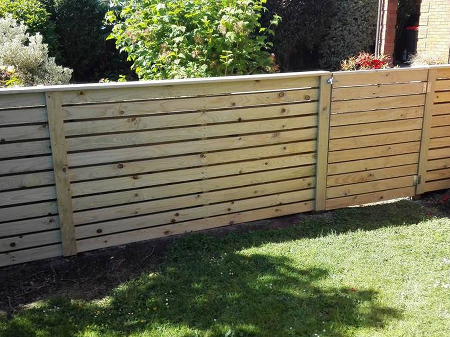Horizontal 100mm timber board fence running along a planted garden border