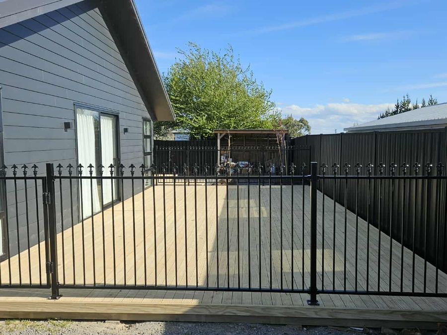 Black alloy fence with spear tops enclosing a new timber deck