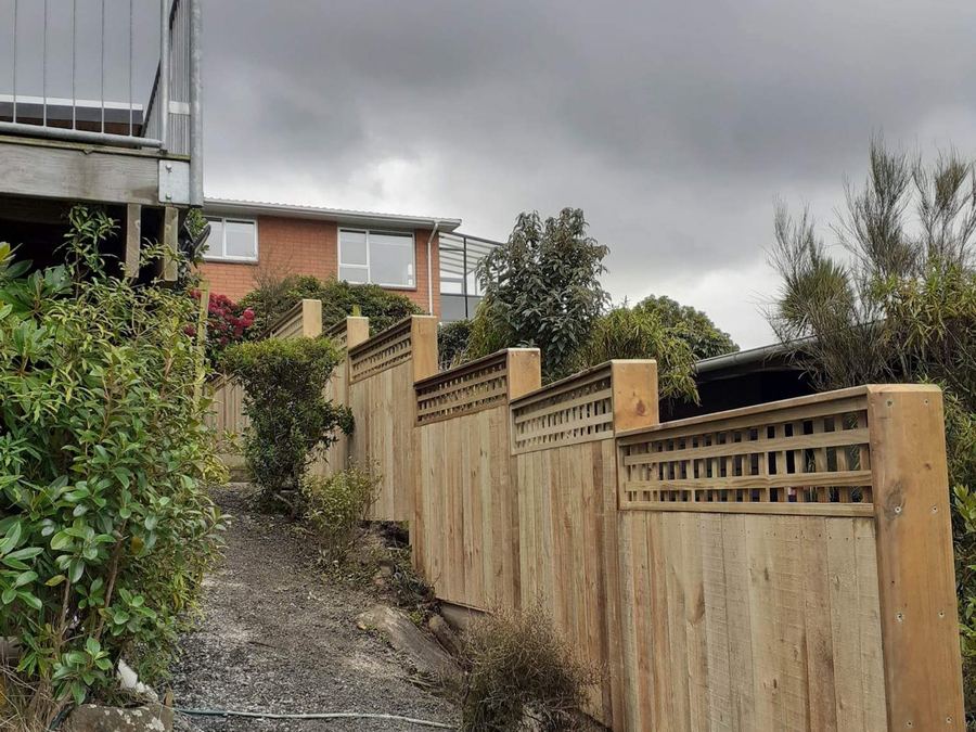 Timber fence with a lattice top panel running up a steep driveway