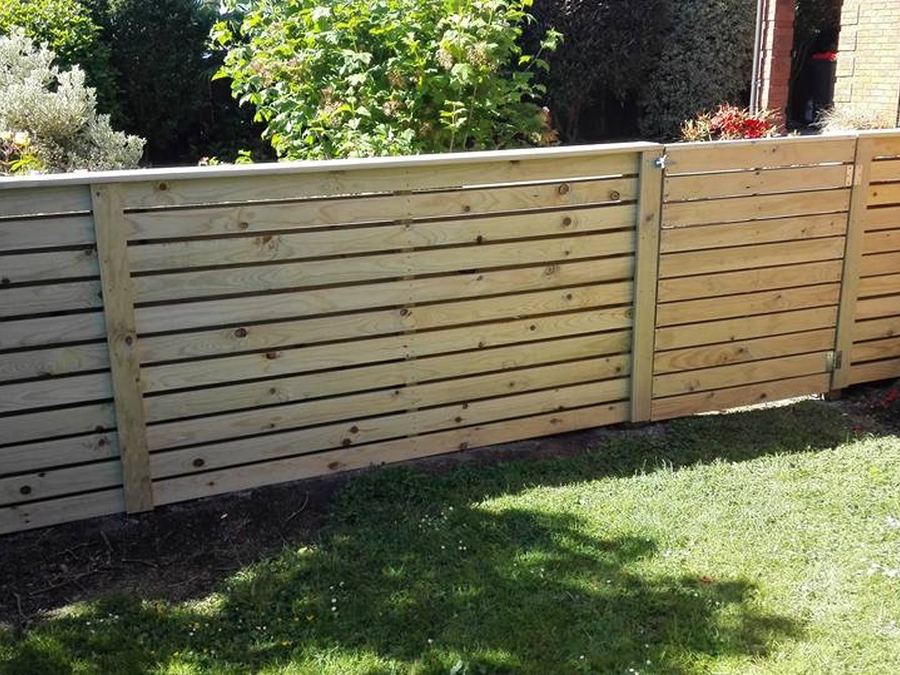 Horizontal timber slat fence along the edge of a back lawn