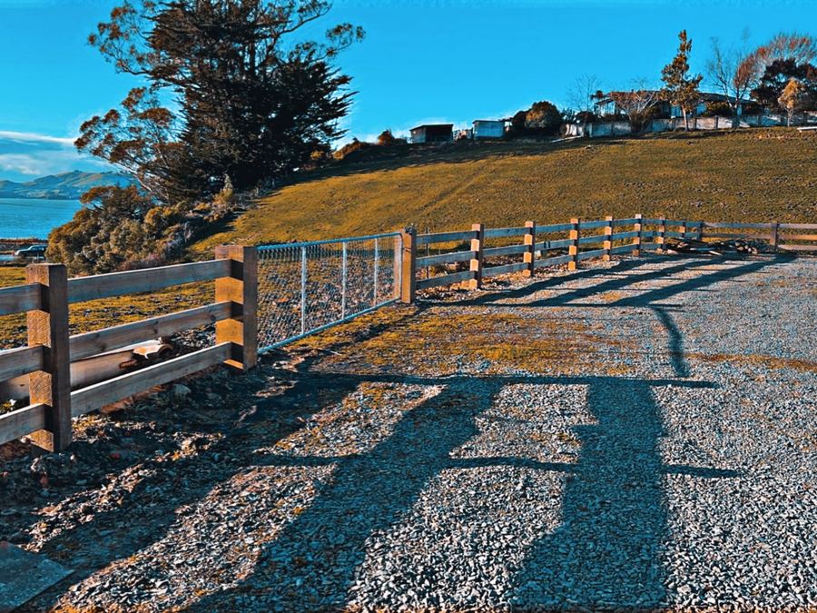 Post and rail fence with reflective markers running above the harbour