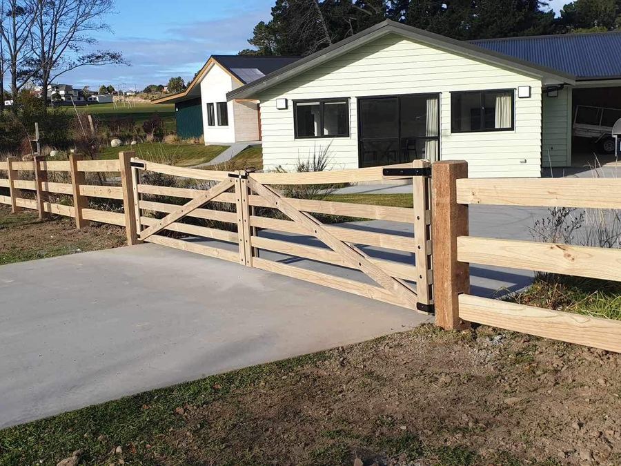 Post and rail fence and timber farm gate at the entrance to a country house