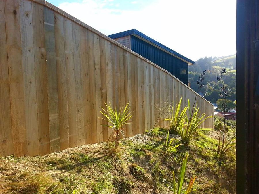 Timber paling fence with capping stepping down a slope