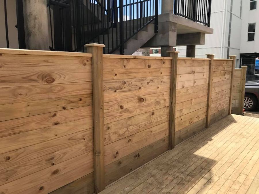 Horizontal timber fence panels beside a timber deck at an apartment block