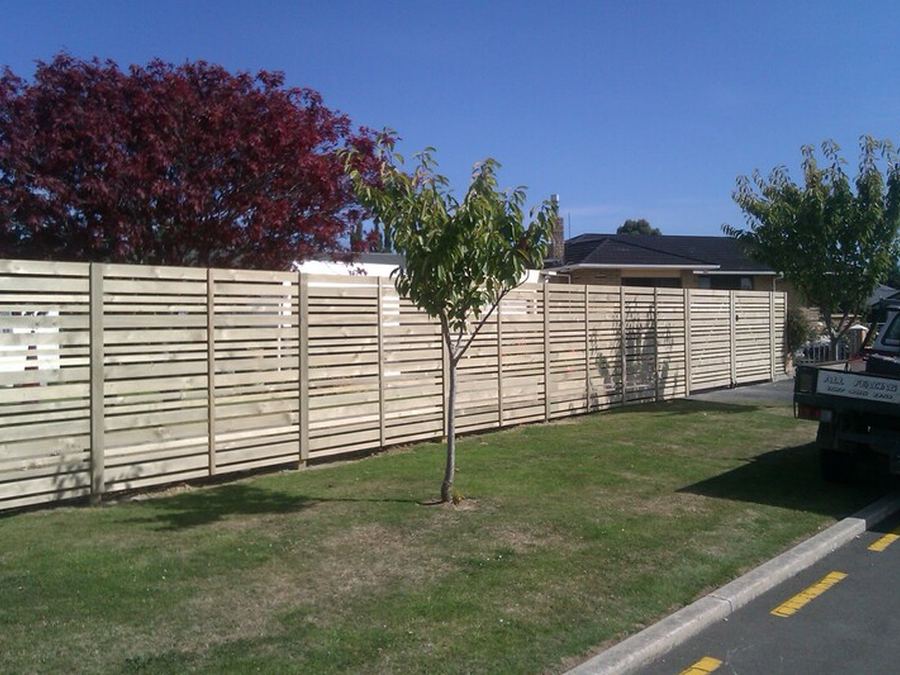 White horizontal slat fence panels along a street frontage