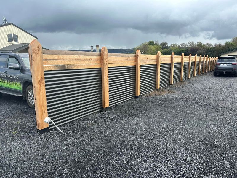 Colour steel infill panels with timber posts and rails, with the All Fencing Solutions ute parked alongside